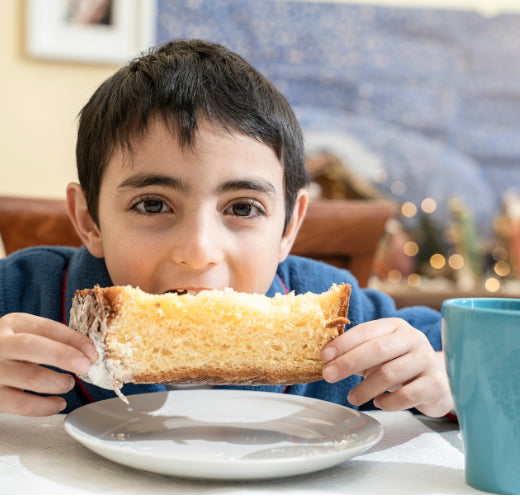 Young boy eating a bog slice of panettone 
