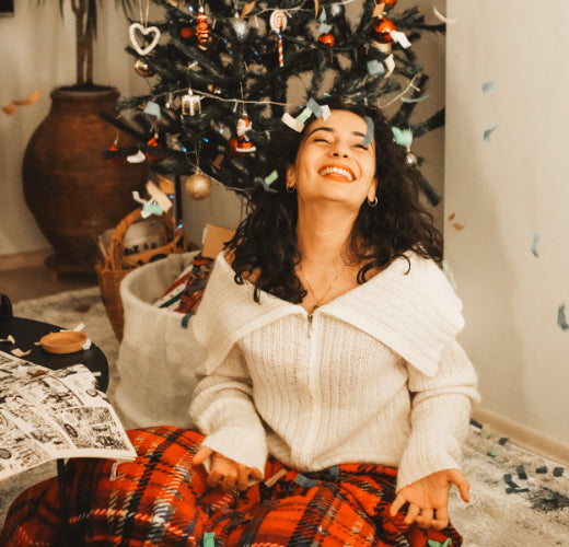 Woman enjoying christmas sitting in front of christmas tree