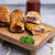 Beef Cheese and Bacon sausage rolls on a wooden board with a blurred background