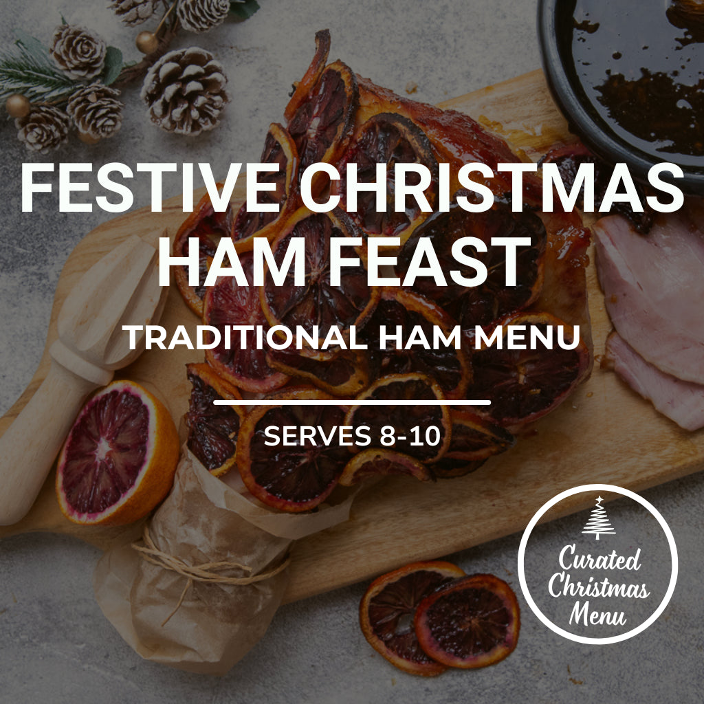 Festive Christmas ham feast with dried oranges and pine cones on a wooden board.