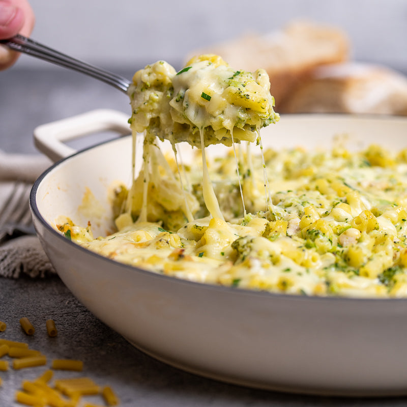 Cheesy pasta being lifted with a fork from a bowl
