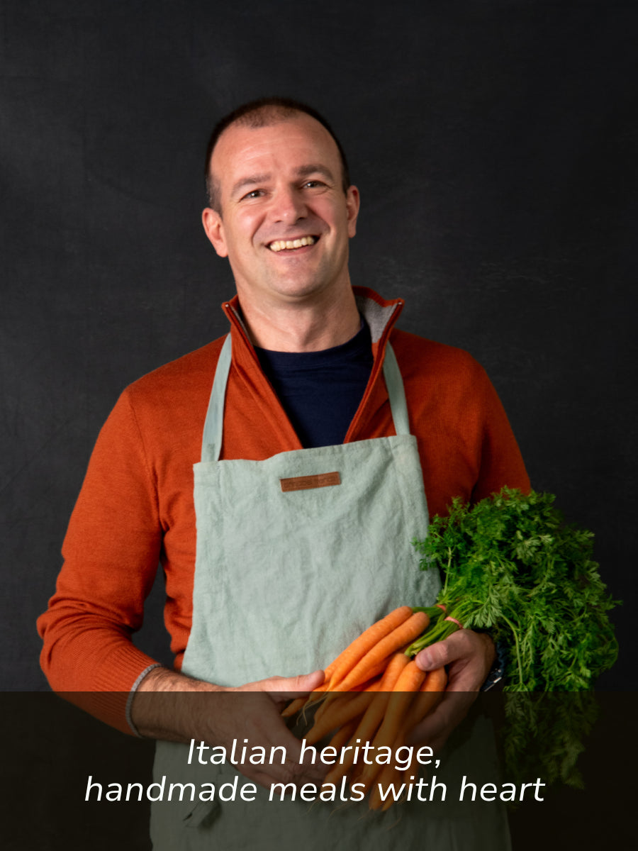 Paolo, FoodSt cook in an apron holding carrots and greens with text about Italian heritage and handmade meals.