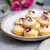 Persian Love Cakes with rose petals and icing on a plate with pistachios 