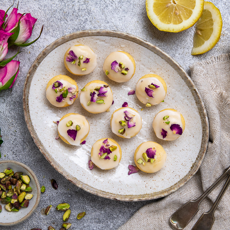 Persian Love Cakes with rose petals and icing on a plate with pistachios 