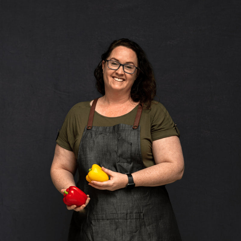 Sliced banana bread on a wooden board with bananas and dates in the background
