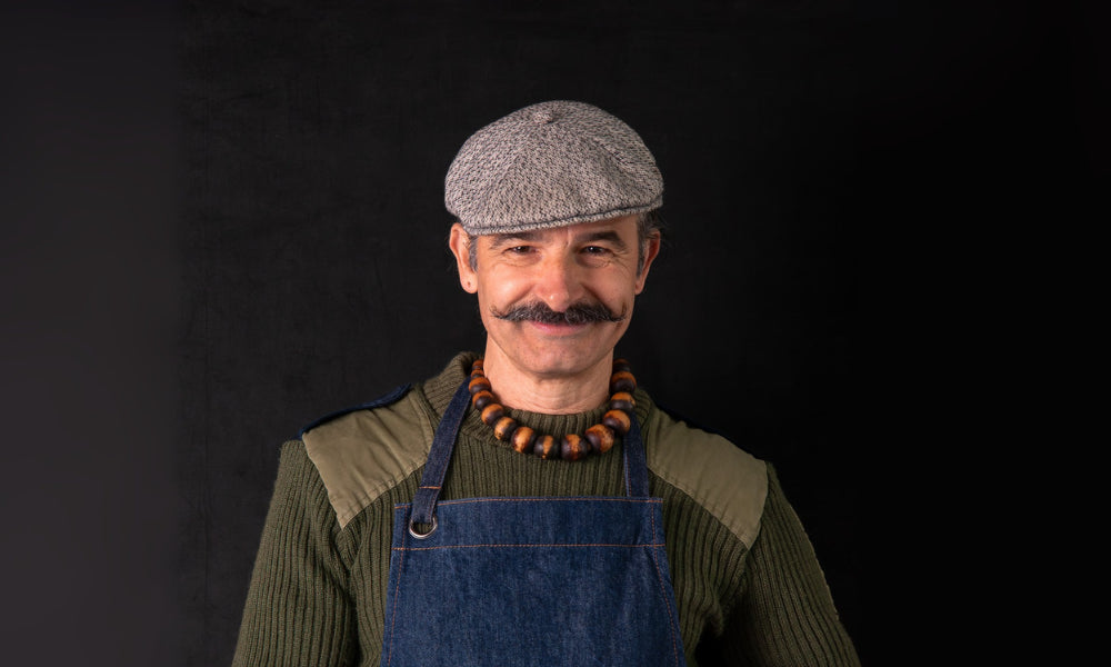 FoodSt cook, Simone wearing a cap and apron against a black background
