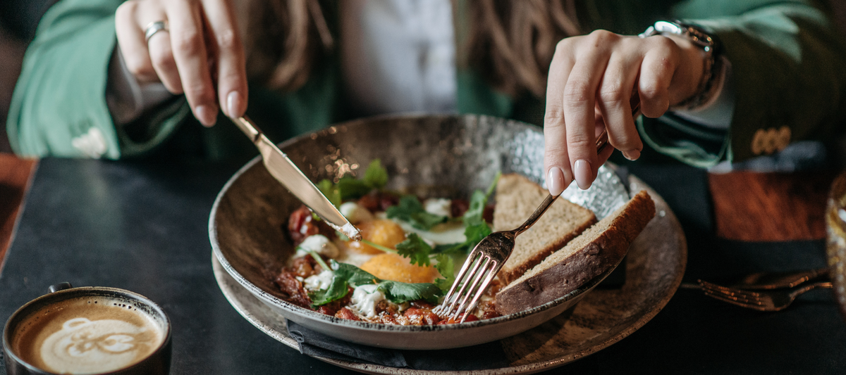 person eating a meal with a fork and knife