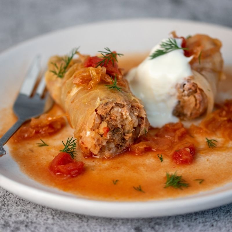 A serving of Amalia's Stuffed Cabbage Rolls topped with sour cream