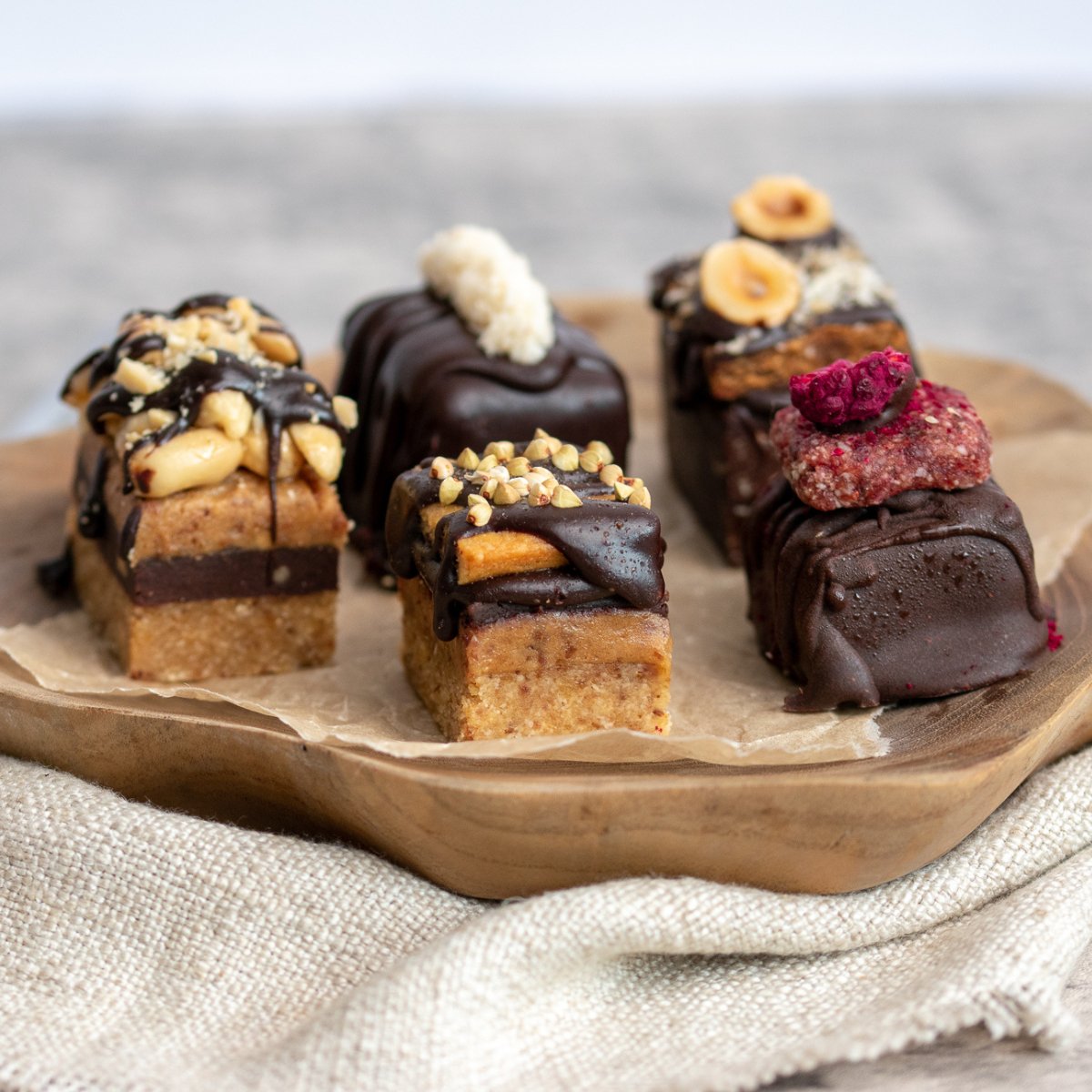 An assortment of Amee's Gourmet Raw Chocolate Treats on a wooden platter
