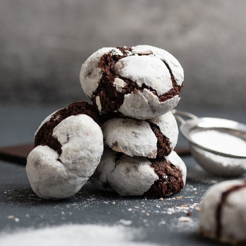 Image of 6 Brownie Bites on a table with chocolate and icing sugar