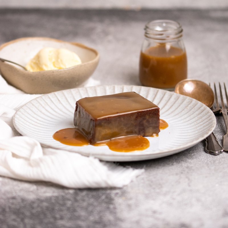 Sticky Date Pudding with Butterscotch  Sauce on a White Plate 