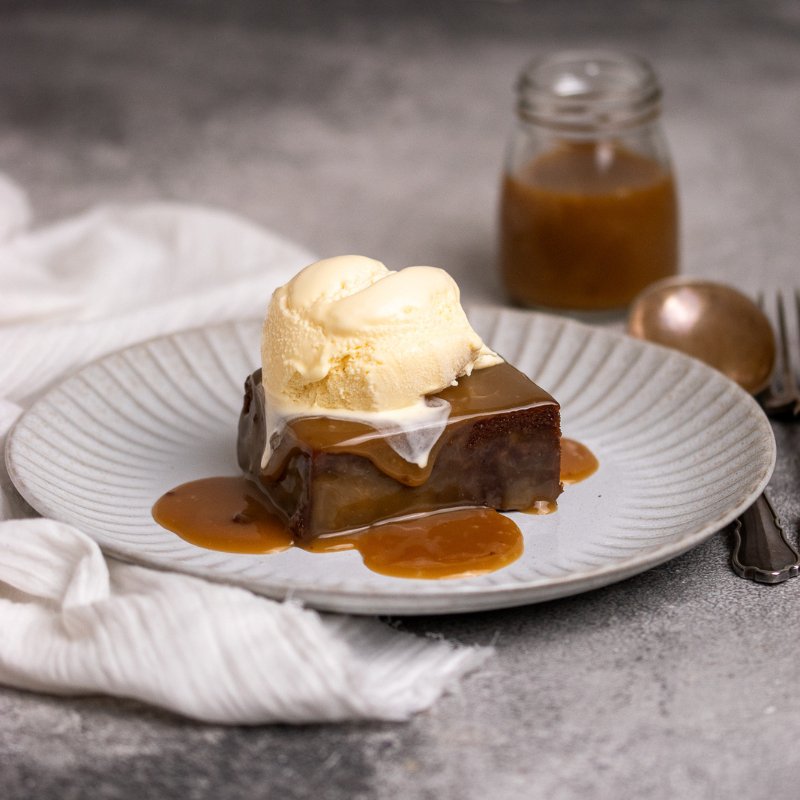 Sticky Date Pudding with Butterscotch  Sauce on a White Plate 