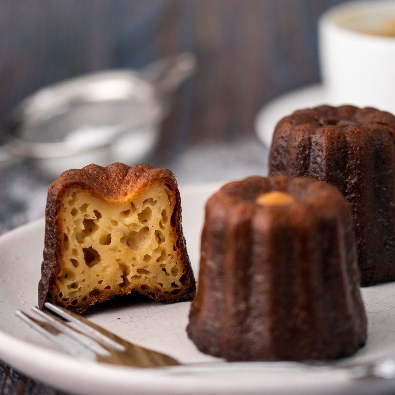 Image of David&#39;s Canelés (x5) on a plate cut in half- FoodSt