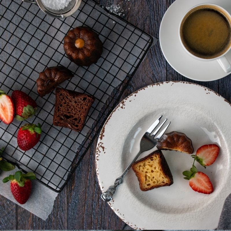 Image of David's Canelés (x5) on a plate cut in half- FoodSt