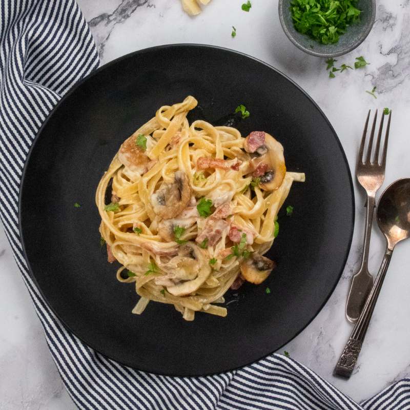 Image of Gavin&#39;s Fettuccine Boscaiola on a black plate - FoodSt