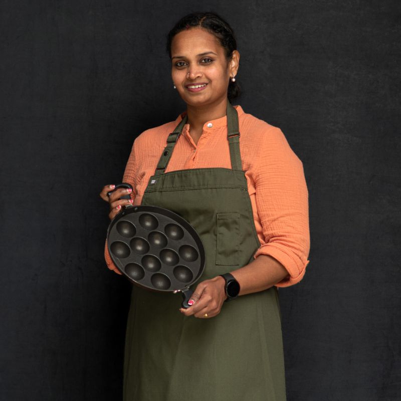 Portrait of Naga in an apron, holding her favourite pan